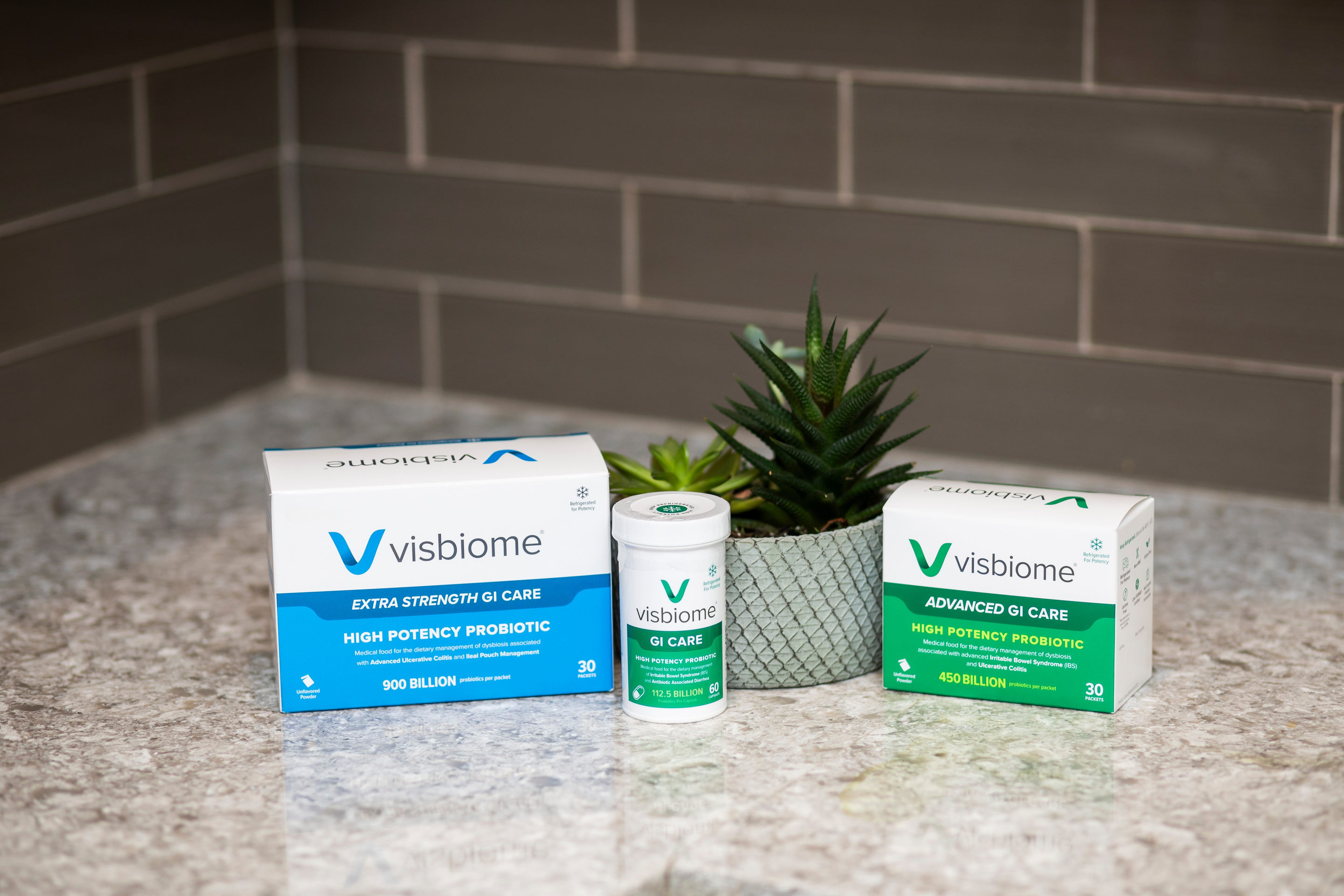 Visbiome probiotic products on a countertop with a plant in the background.